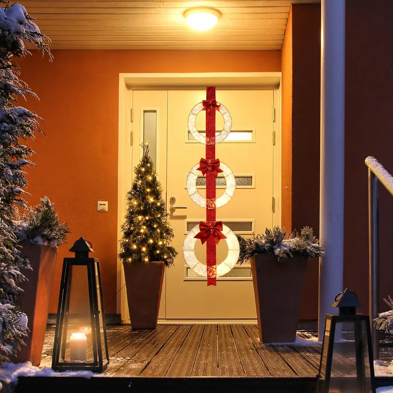 Zestaw trzech podświetlanych wieńców bożonarodzeniowych o długości 1,77 metra z 450 diodami LED i eleganckimi akcentami w postaci czerwonych wstążek.